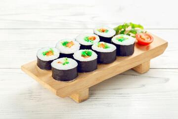 Roll vegan with Chuka seaweed on wooden plate.