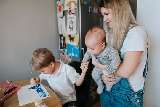Young mother with her children at home.