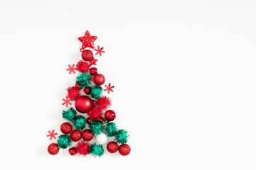 Christmas creative minimal composition. Xmas red and green decorations on white background. Christmas, New Year, winter concept. Flat lay, top view, copy space