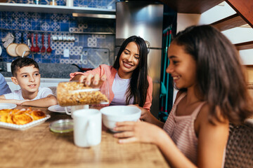 Latin family eating healthy breakfast in the kitchen