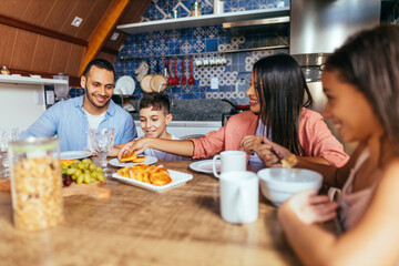 Latin family eating healthy breakfast in the kitchen