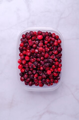 Frozen cranberries in a plastic container