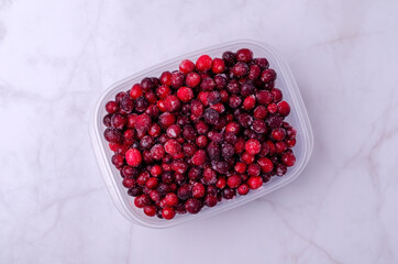 Frozen cranberries in a plastic container