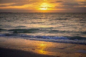 Brilliant sunset over the ocean waves reflecting on the water on the beach in Florida before Hurricane Ian