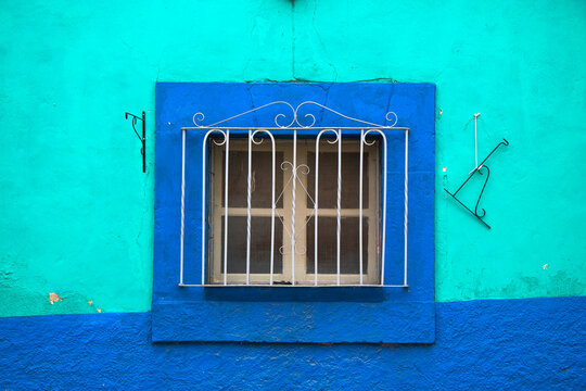 Ventanas tradicionales de los pueblos  mexicanos del centro del Pa&iacute;s, en colores azules intensos o chillantes, con barrotes simples de hierro y marcos de ventanas en madera.