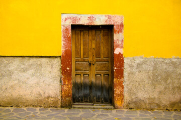 Fachada deslavada de una casa de la época minera en el pueblo de Armadillo de los Infantes San Luis Potosí México, aún conserva la puerta original de madera, pueblos mágicos.