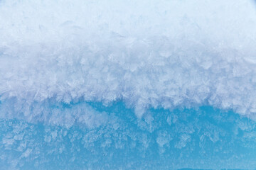 Winter cold abstract natural background of snowy blue ice floe with ice crystals. Color gradation from blue to white. Empty space for text, blank, mock up (focus on center, top and bottom blurred)