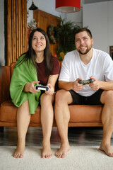 Beautiful couple playing videogames at home. Spend time together. Lifestyle at home