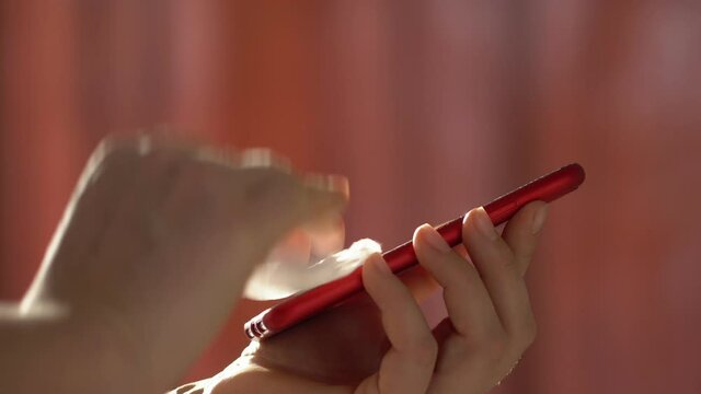 Close-up of woman hand using wet wipe and sanitizer to clean cell phone screen. People cleaning and disinfecting mobile telephone monitor to kill virus and germs. Female hands holding smartphone