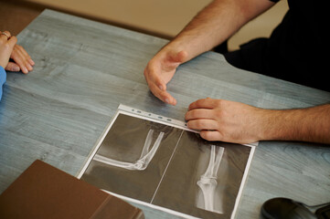 The doctor's consultation. There is an X-ray on the doctor's desk.