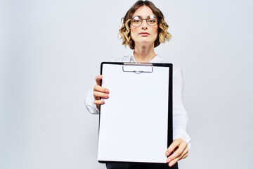 Business woman with a folder of white documents in her hand on a light background And hairstyle glasses model