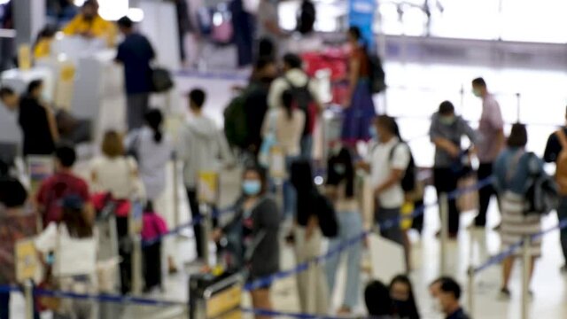 Blurred And Unrecognizable Asian People Waiting To Check In At The Airport. Everyone Wearing Disposal Face Mask For Protect Coronavirus. Airport Open After Covid-19 Epidemic