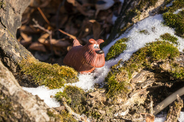 Lonely toy dog in the autumn forest brightly lit by the sun; the concept of solitude, unity with nature, tranquility