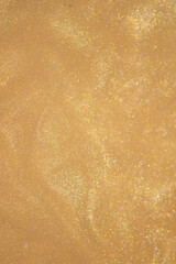 Golden glitter dust on dark background.