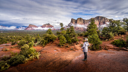 Fototapeta premium Woman looking at the Red Rocks of Munds Mountain and Surrounding Mountains near the town of Sedona in northern Arizona in Coconino National Forest, USA