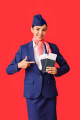 Beautiful stewardess with documents on color background