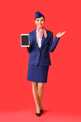 Beautiful stewardess with tablet computer on color background