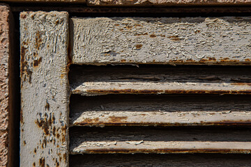 Rusty metal grilles, painted with paint and peeled off from old age, ventilation holes for air ingress in industrial facilities, an electric shield, an opening door