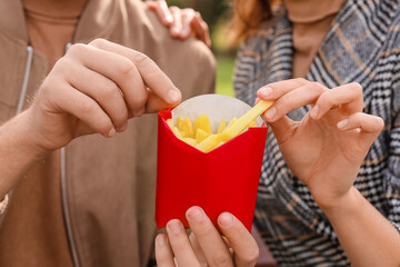 Young couple eating french fries, closeup