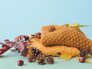 Autumn composition with stylish clothes on table against color background