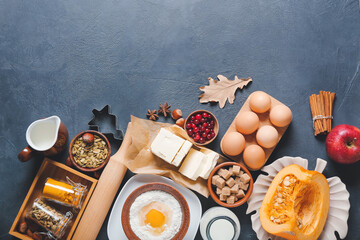 Ingredients for preparing pumpkin pie on dark background