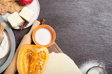 Ingredients for preparing pumpkin pie on dark background