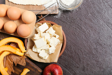 Ingredients for preparing pumpkin pie on dark background