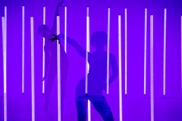 Collage of shadows sports young woman dancer performing solo in the studio on a colorful background with neon lighting tube. Dance color poster.