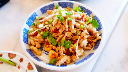 Fried pork with shrimp, pork, dong quai or tang kui and goji in white dish or plate at China restaurant. Healthy food of Chinese people or Asian. Delicious meal and Food for nourishing blood.