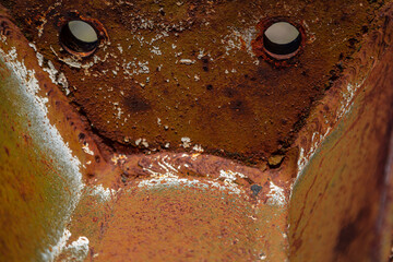 On a rough wall or floor, paint flakes off. Corrosion and rust of metal. Old dilapidated wall.
