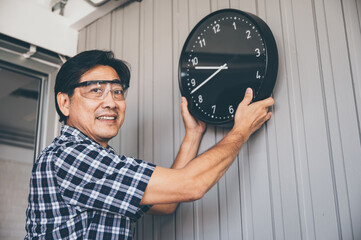Grandfather repair and hanging clock on the wall at home, sets time clock