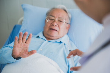 Obraz premium Surgeon doctor visiting senior male patient in hospital bed in geriatric unit