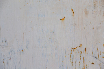 On a rough wall or floor, paint flakes off. Corrosion and rust of metal. Old dilapidated wall.