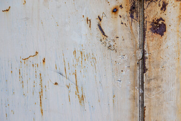 Obraz na płótnie Canvas On a rough wall or floor, paint flakes off. Corrosion and rust of metal. Old dilapidated wall.