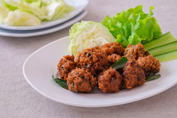 Deep fried spicy minced pork served with vegetable on plate, Thai food