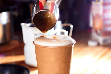 The practice latte art with select focus with coffee. Close up shot hand of barista making freshly latte art in paper cup. How to make latte art