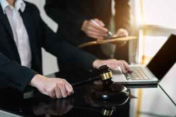 Legal counsel presents to the client a signed contract with gavel and legal law. justice and lawyer concept in office.