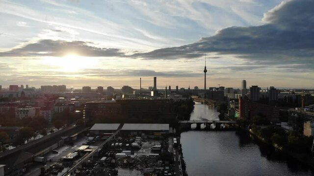 Berlin 4k drone shot from aerial perspective with left swing and left to right motion movement at sunset across the spree river looking west towards the television tower.