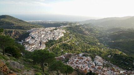 Fototapeta na wymiar Nerja village architecture with white painted houses in a green hill landscape along the Costa del Sol in Spain.
