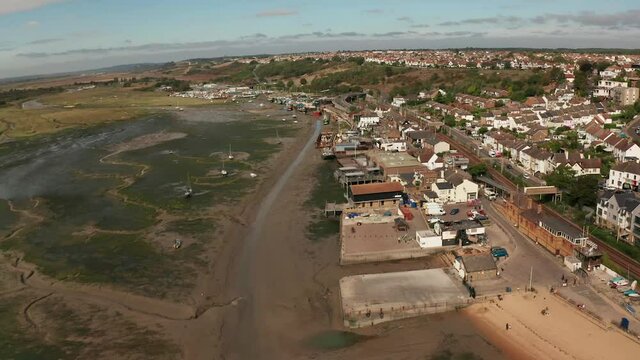 Smooth flight over wharf business and train tracks coastal fishing village over marshes. Aerial shot Mavic 2 pro. HD 50fps