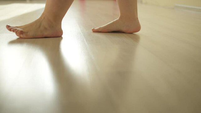 woman walking naked on the laminate floor indoors