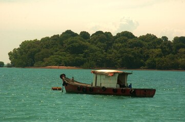 wooden fishing boat resting on the sea in Port Dickson Malaysia

