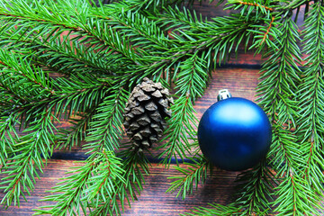 Christmas background. Fir tree and a christmas blue baubles over wooden board