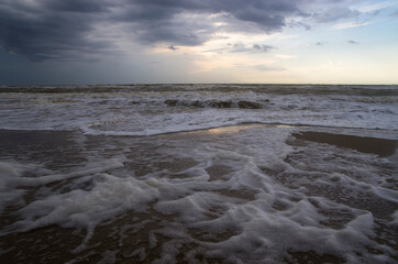Fototapeta na wymiar Foam on the shore of a stormy sea, landscape