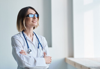 professional doctor woman with glasses near window and stethoscope