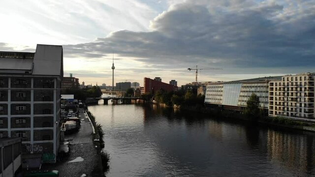 Drone 4k rising shot at sunset in Berlin over the spree river looking west towards the tv tower fernsehturm and the Schilling bridge with traffic