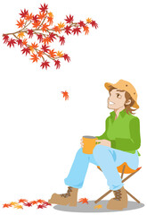 ソロキャンプでコーヒーを飲みながら紅葉を眺める女性