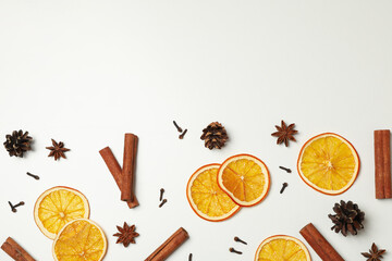 Fototapeta na wymiar Cinnamon, orange slices and cones on white background