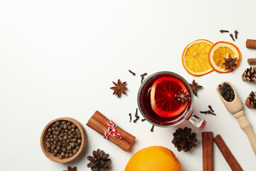 Cup of mulled wine and ingredients on white background
