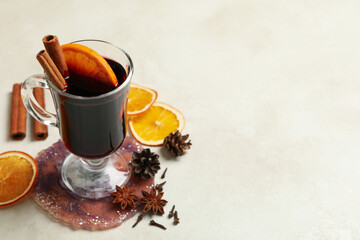 Glass of mulled wine and ingredients on white background